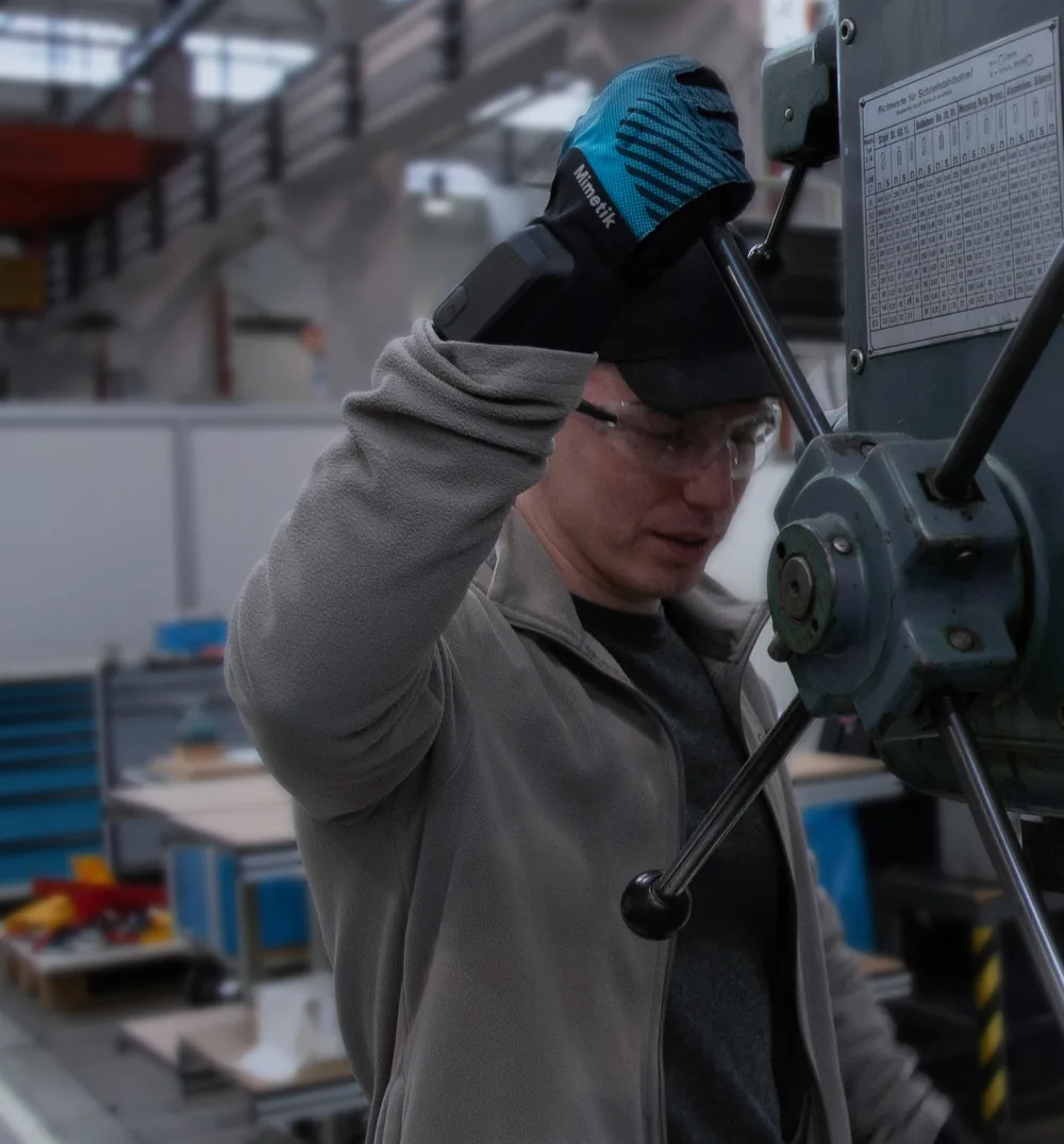 Industrial worker using the Mimetik AI Glove on factory equipment